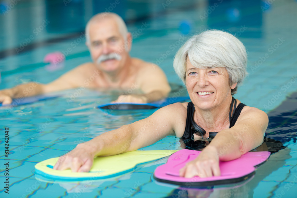 active senior doing aqua gym in outdoor swimming pool - obrazy, fototapety, plakaty 