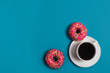 A cup of americano with two pink donuts on a blue background