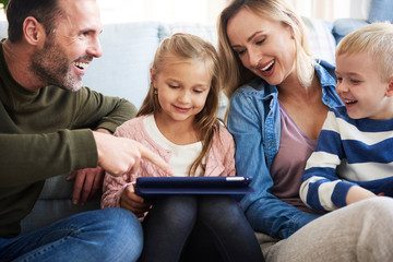 Wall Mural - Cheerful family using tablet in living room