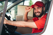 © Drobot Dean - Image of happy bearded delivery man smiling and driving van