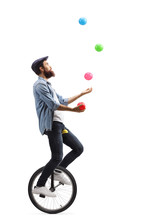 Man Riding A Unicycle And Juggling With Balls