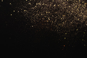 Wall Mural - Christmas Gold glitter on black background. Holiday abstract texture