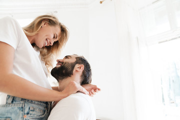 Beautiful happy young couple in love embracing at home