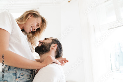 Photographie Beautiful happy young couple in love embracing at home