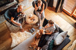 © Soloviova Liudmyla - Cozy family tea time. Father, mother and son  at the home living room. Boy lying in comfortable sofa and  stroking their beagle dog and smiling. Peaceful family moments concept image.