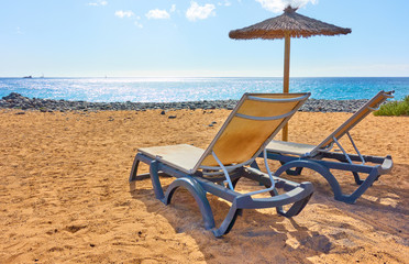 Wall Mural - Beach with parasol and chaise longues by the sea