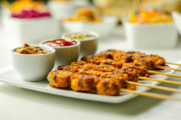 Satay chicken breast marinated in Indonesian style spices and grill on wooden skewers with dip peanut, ketchup, mustard