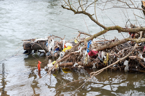 Plastic bags, bottles, garbage and trash dumped in the river in nature. River pollution. Rubbish and waste floating in contaminated lake. Ecological and environmental disaster. Ecology issue. Garbage.