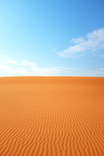 Bright Orange Desert Sand Color Against A Bright Blue Sky For A Hot Summer Background