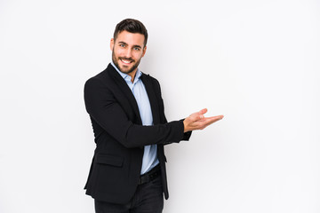 Young caucasian business man against a white background isolated holding a copy space on a palm.