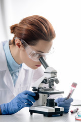 Wall Mural - genetic consultant in white coat using microscope in lab