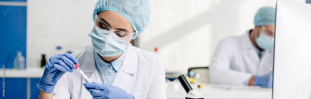 panoramic shot of molecular nutritionist holding test tube in lab - obrazy, fototapety, plakaty 