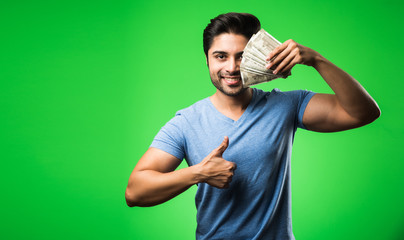 Indian happy man with money fan, standing isolated against green chroma screen