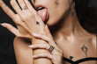 Cropped image of young sassy woman licking her palm