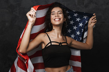 Sticker - Image of young caucasian woman smiling and holding american flag