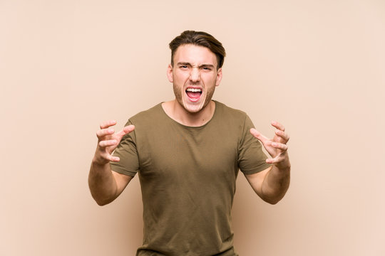 Young caucasian man posing isolated screaming with rage.