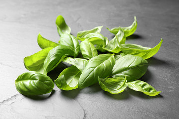 Pile of fresh basil leaves on grey table