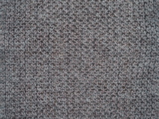 Knitted fabric texture. Gray. Simple knitting with front and back loops. Knitting on the knitting needles. Horizontal lines.