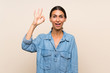 Young woman over isolated background surprised and showing ok sign