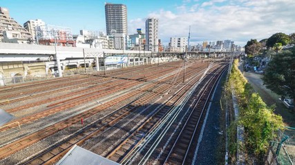 Canvas Print - Train passing on railway in the Tokyo city and city view in the background. Tokyo's train/subway train moving in city center of Tokyo. Tokyo Olympic 2020 4K UHD video of Tokyo city's transportation