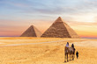 Egyptian Pyramids of Giza and the tourists on a camel