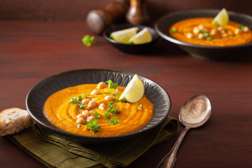 Poster - creamy carrot chickpea soup on dark rustic background