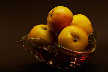 Gifts of nature, on a gradient background delicious, sweet apples in a beautiful glass vase.