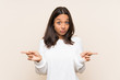 © luismolinero - Young brunette woman with white sweater over isolated background pointing to the laterals having doubts