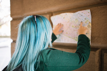 Girl with backpack and paper map waving