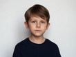 © polya_olya - Portrait of a serious little boy on a white background