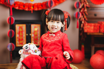 Wall Mural - Chinese toddler girl with traditional dressing up and holding dancing lion with 