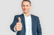 © Viktoriia - Freestyle. Mature businessman standing isolated on white thumb up blurred smiling positive