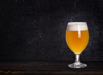 Wall Mural - Glass of beer on wood dark background with copyspace for text