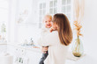 © Ekaterina Pichukova - Mother and daughter in a bright kitchen. Homeliness. Joyful baby and his mom.