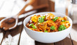 bowl of farfalle bowtie pasta with beef, basil leaves and tomato sauce