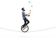 Bearded Male Hipster Juggler With Balls Riding A Unicycle On A Rope