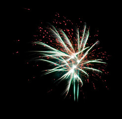 Big firework in the form of diverging red and green threads isolated on a black background