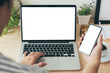 © panitan - mockup image blank screen computer,cell phone with white background for advertising text,hand man using laptop texting mobile contact business search information on desk in office.marketing,design