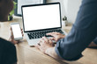 © panitan - mockup image blank screen computer,cell phone with white background for advertising text,hand man using laptop texting mobile contact business search information on desk in office.marketing,design