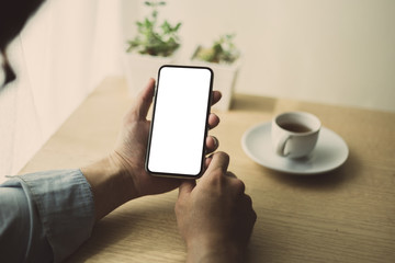 Mockup image blank white screen cell phone.man hand holding texting using mobile on desk at office.background empty space for advertise text.people contact marketing business,technology 