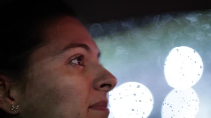 Wall Mural - Closeup of female driver at night. Candid woman face driving in the evening