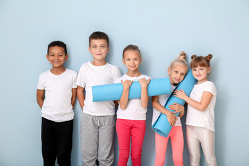 Wall Mural - Little children with yoga mats near color wall