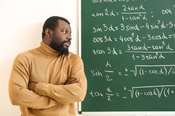 Wall Mural - African-American math teacher near blackboard in classroom