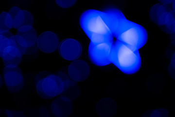 Defocused of blurred phantom blue star bokeh circle light from lighting bulb in the dark night for abstract background texture patterns