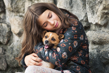 beautiful teen girl hugging her new pet adopted friend dog from rescue shelter