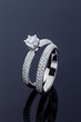 Female engagement and wedding rings with diamonds on black background