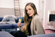 Young attractive woman sitting on couch with sparkling wine