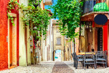 Fototapeta Na drzwi - Small town narrow street view with colorful houses in Malcesine, Italy during sunny day. Beautiful lake Garda.