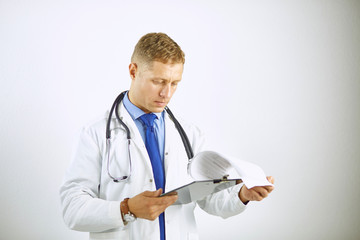 Wall Mural - Young confident doctor in a white coat with a stethoscope