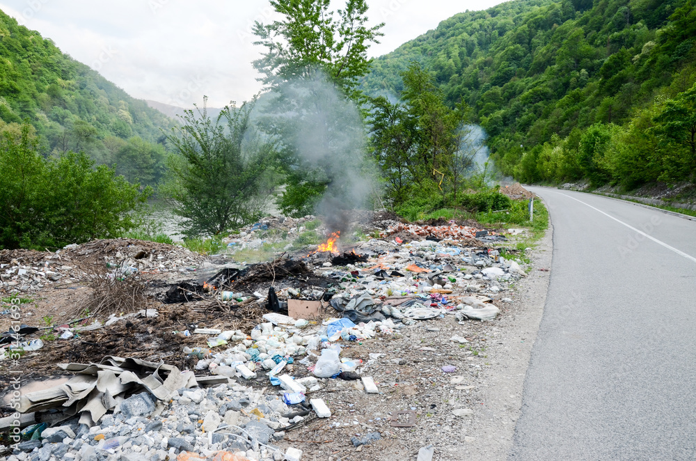 Illegal waste dumping near the river. Piles of garbage in nature. Open ...